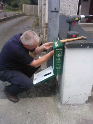 Mutt mitt dispenser being installed